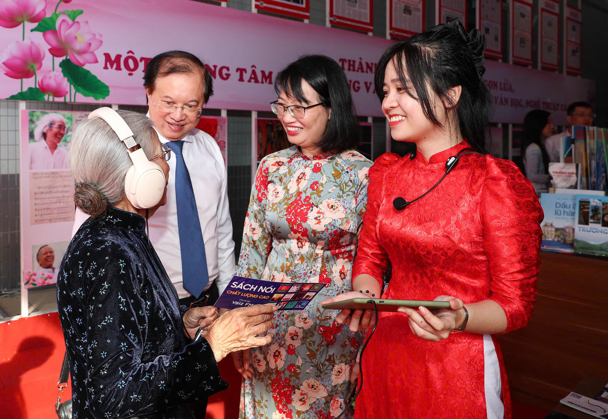 NSƯT Phi Điểu, Thứ trưởng Bộ Văn hóa - Thể thao và Du lịch Tạ Quang Đông và Phó Chủ tịch UBND TP HCM Trần Thị Diệu Thúy nghe sách nói tại triển lãm. Ảnh: NLD.