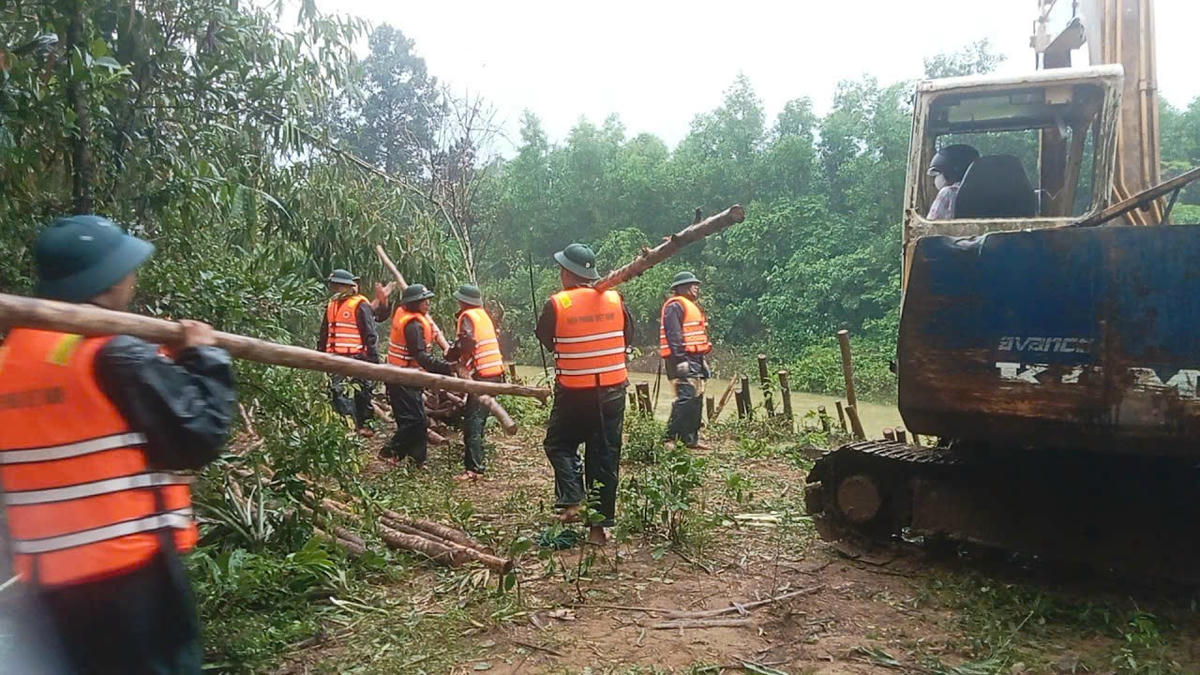 Cán bộ, chiến sĩ cùng phương tiên máy móc được huy động để khắc phục bờ sông bị sạt lở. Ảnh: B.T.
