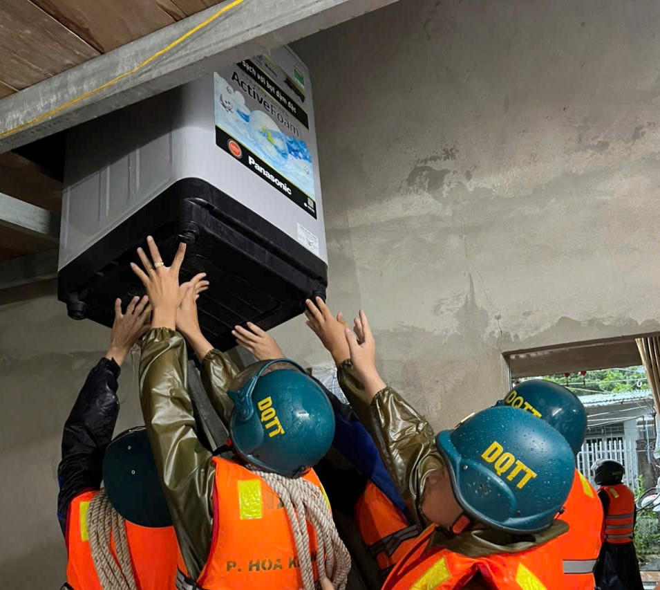Lực lượng chức năng di chuyển đồ đạc của người dân ở vùng ngập nước lên vị trí cao. Ảnh: CV.. 