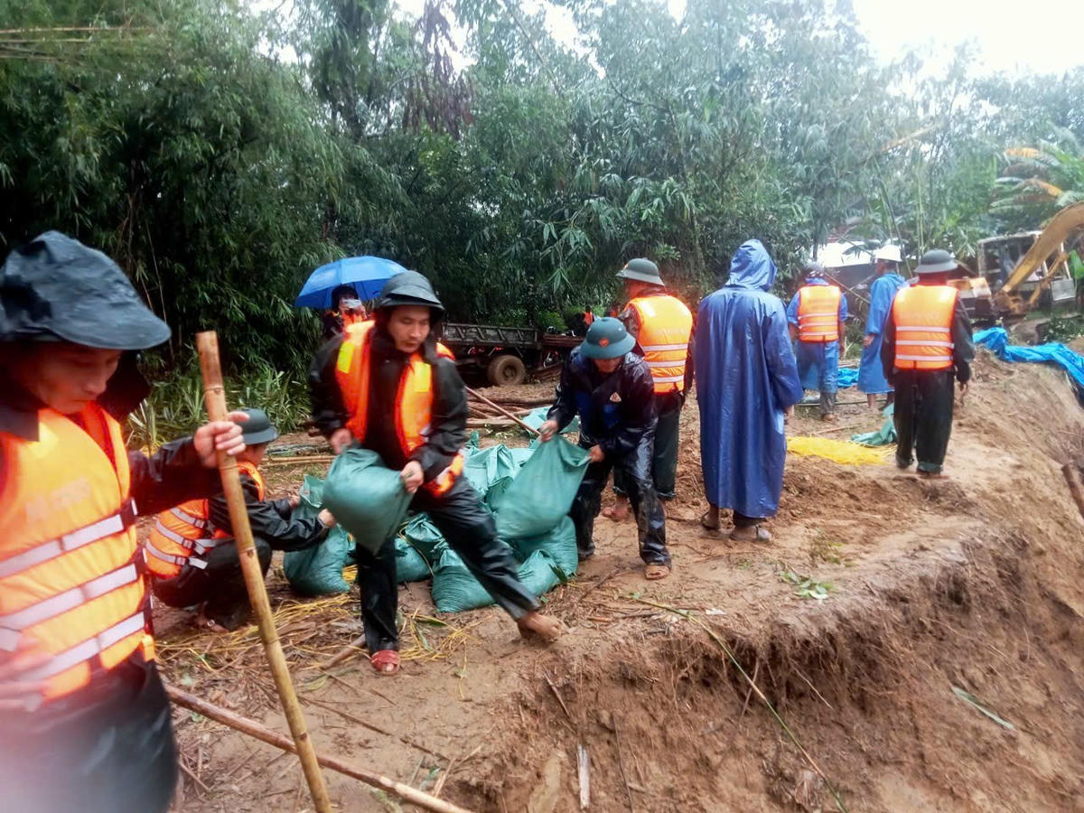 Hàng chục cán bộ, chiến sĩ gia cố bở sông bị sạt lở do mưa lớn. Ảnh: B.T.