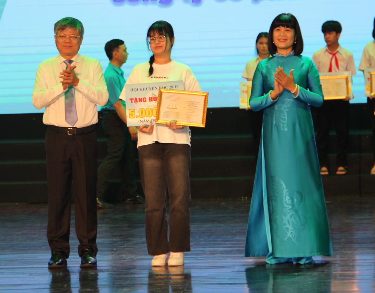 Lãnh đạo VRG và đại diện Tổng Liên đoàn Lao động Việt Nam trao thưởng cho các em. Ảnh: Q.Định.