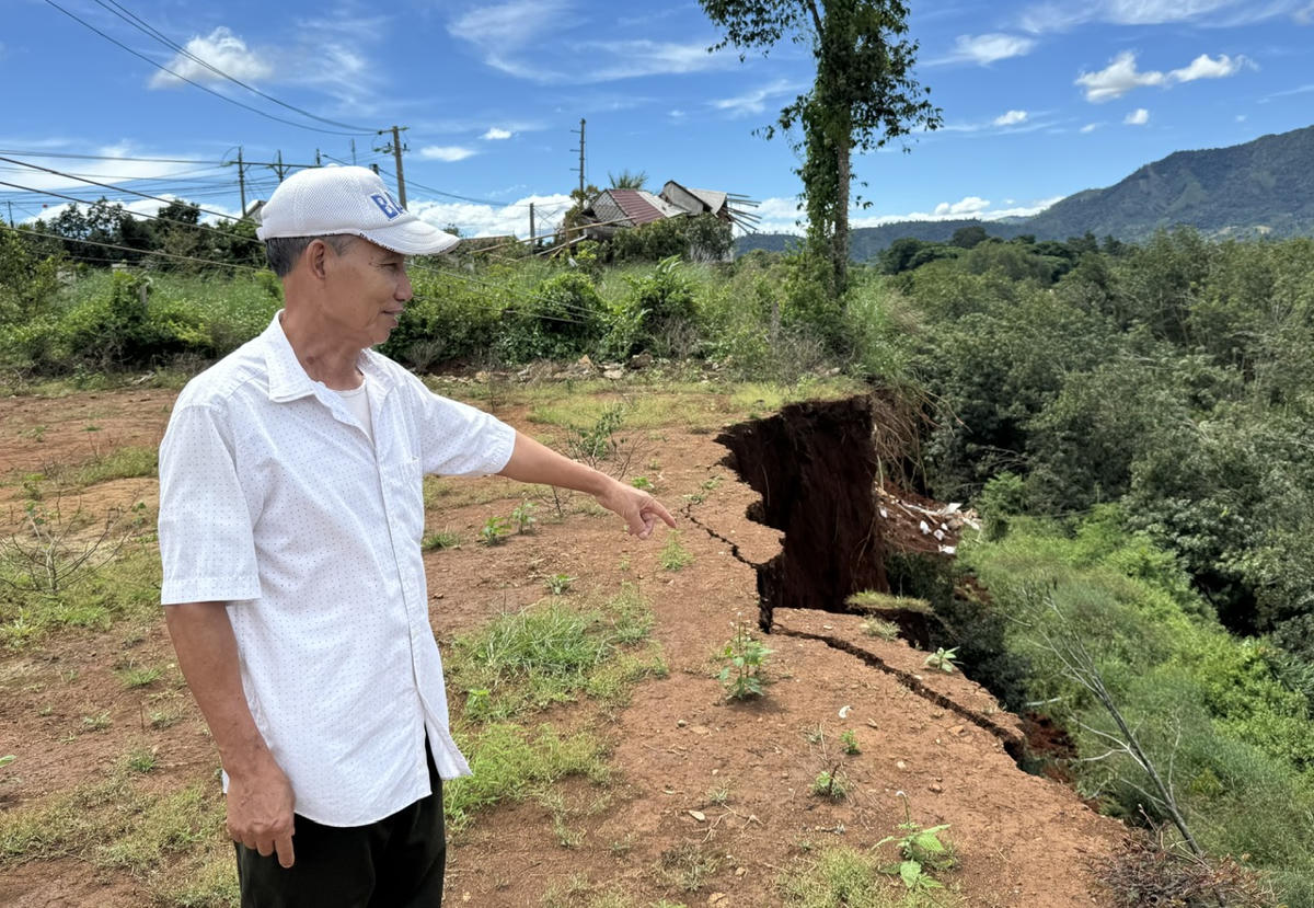 Ông Nguyễn Xuân Bản chỉ đoạn đường tuyến đường vào đi Trạm truyền tải 500kV sạt lở nghiêm trọng. Ảnh: Đình Sang.