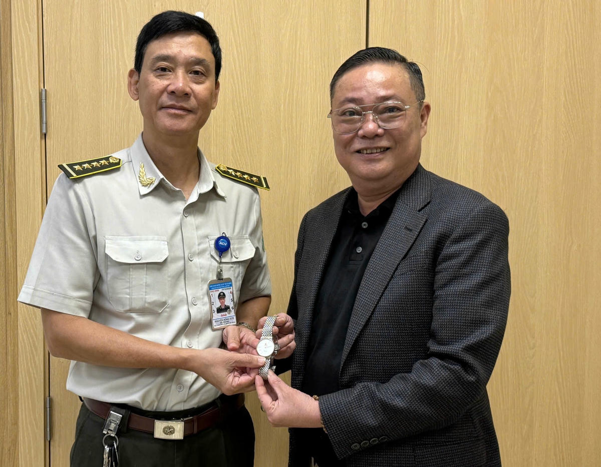 Ông Nguyễn Hồng Sơn bàn giao đồng hồ cho hành khách. Ảnh: Nguyễn Tú.