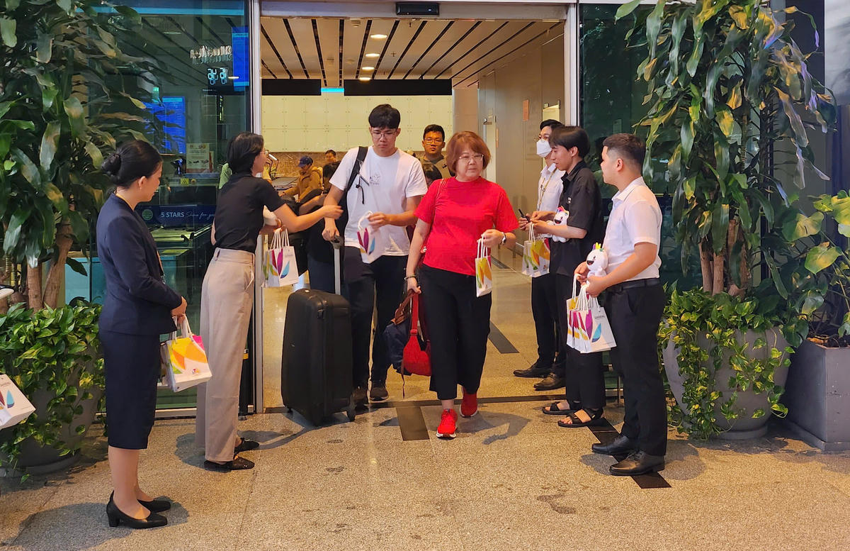 Du khách được chào đón, tặng quà lưu niệm ngay khi đến nhà ga quốc tế. Ảnh: Nguyễn Tú.