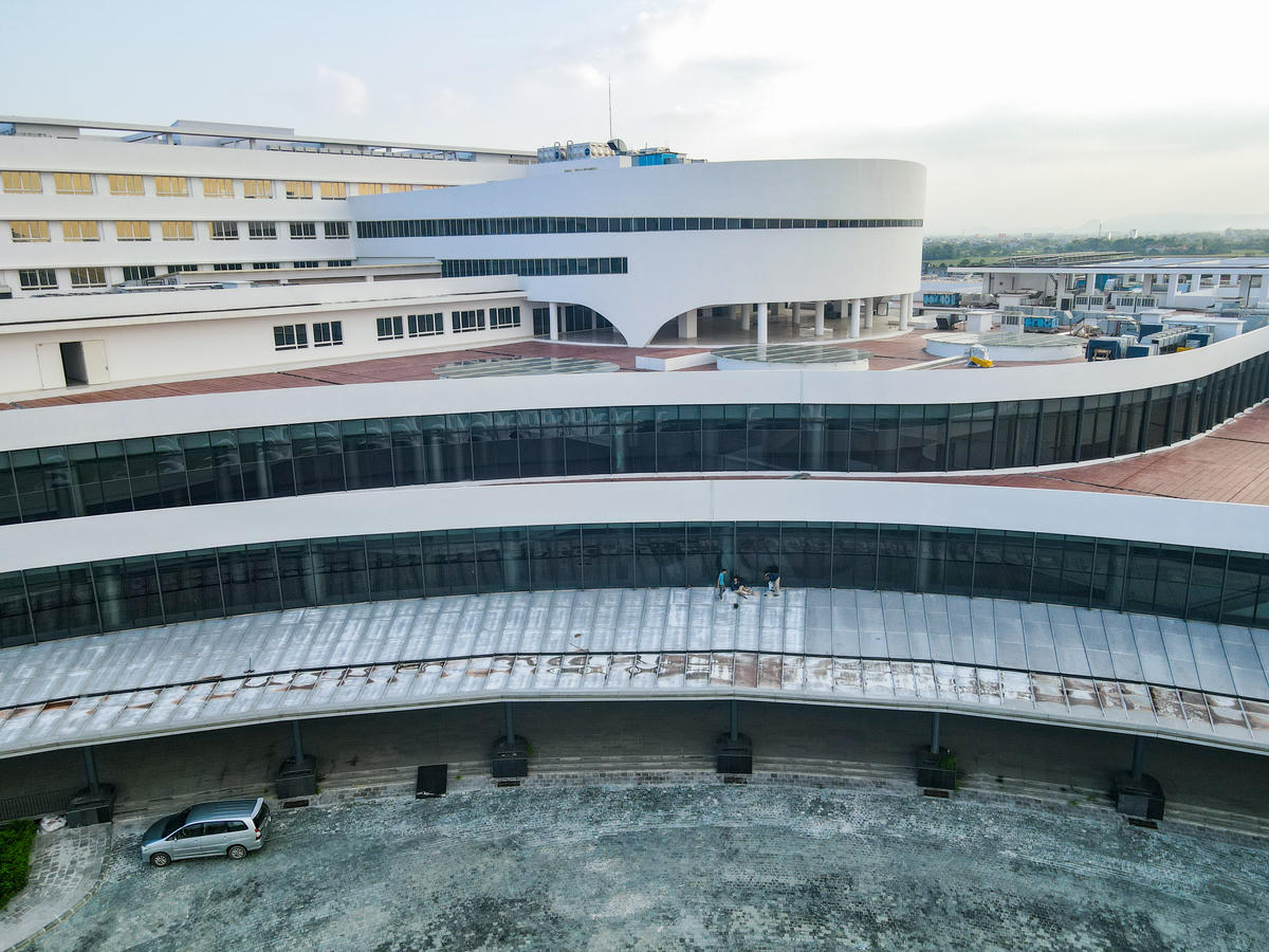 Năm 2019, công trình từng được đưa vào vận hành thử một phần, nhưng đến tháng 3/2020 phải tạm dừng do vướng mắc về thủ tục, vốn và thiếu trang thiết bị y tế đồng bộ. Sau một thời gian dài bị 'đắp chiếu', nhiều hạng mục xuống cấp, khuôn viên bị bỏ hoang. Đến năm 2025, Chính phủ chỉ đạo quyết liệt để 'hồi sinh' dự án này. Ảnh: Đình Minh