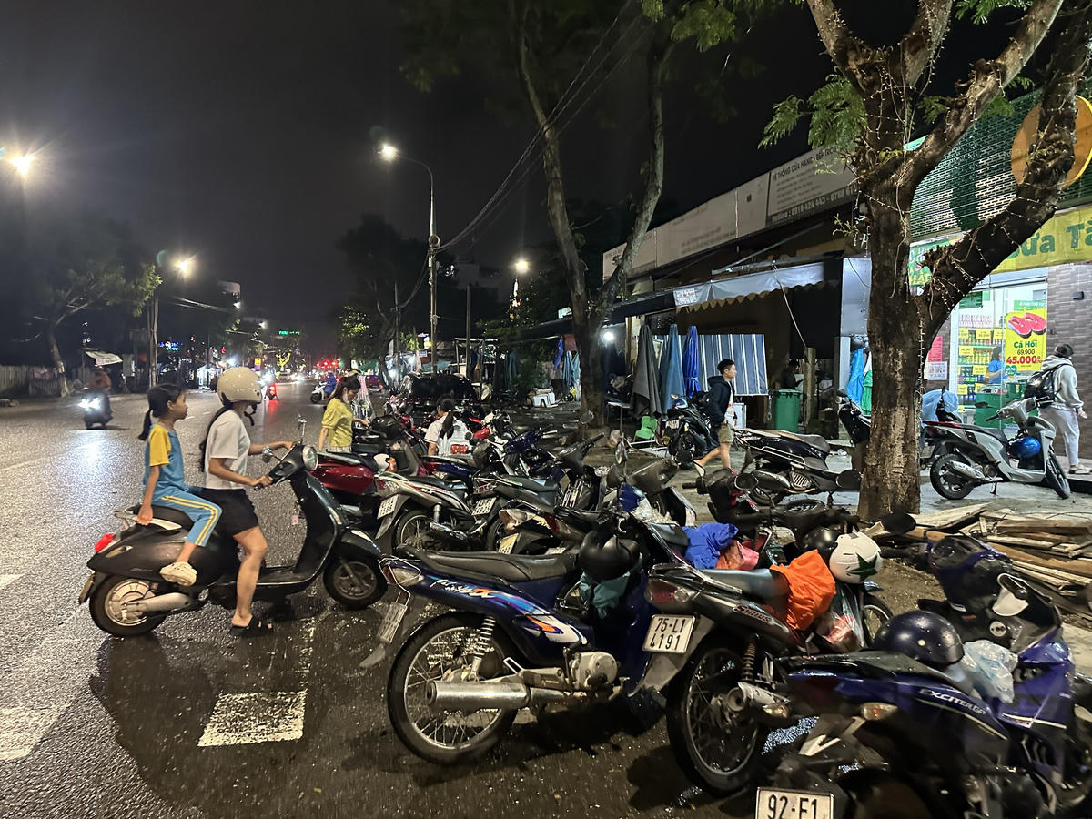 Người dân để xe tràn xuống đường để vào mua hàng hóa tích trước trước bão số 12. Ảnh: Nguyễn Tú.