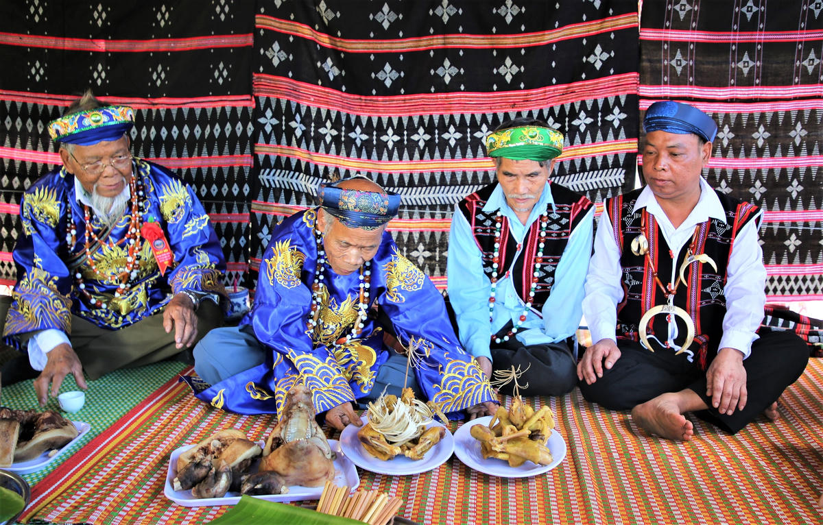 Già làng chuẩn bị mâm gà luộc và thịt hiến tế, đặt trước mặt để cùng chia sẻ trong lễ kết nghĩa.