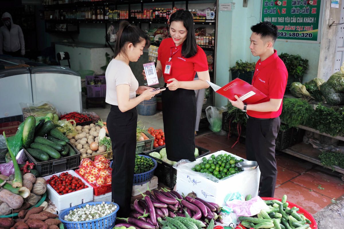 Cán bộ Agibank hướng dẫn tiểu thương sử sụng mã QR code trong thanh toán