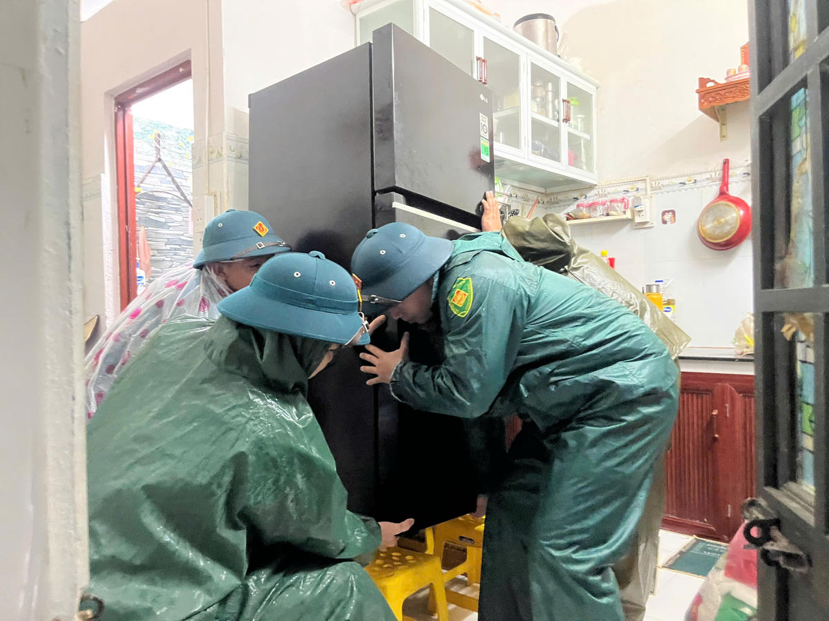 Di dời đồ đạc trong nhà người dân lên vị trí cao để chống ngập nước. Ảnh: Nguyễn Tú.