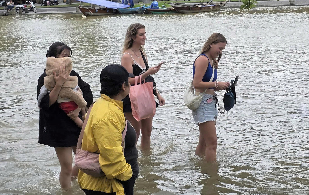 : Du khách nước ngoài vui vẻ khi lội nước ngắm nhìn phố cổ Hội An. Ảnh: Chí Đại.