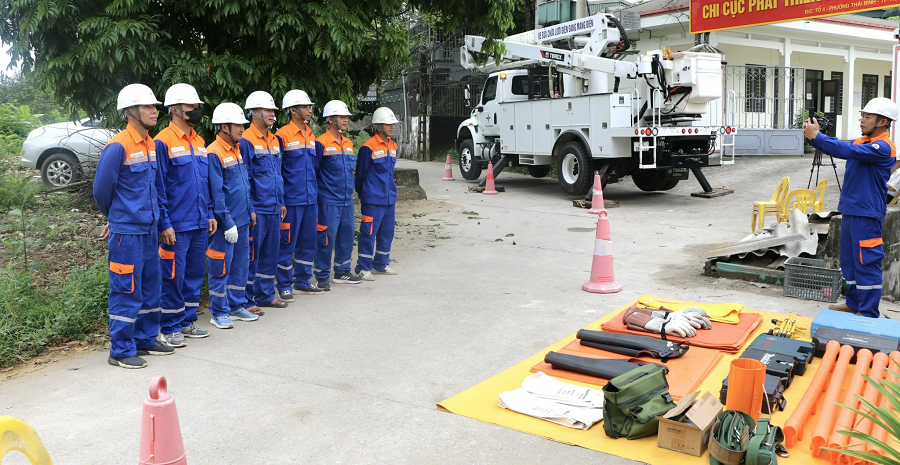Công nhân Đội sửa chữa điện Hotline PC Phú Thọ kiểm tra dụng cụ, thiết bị và chụp ảnh nhóm trước khi bắt đầu ca làm việc.