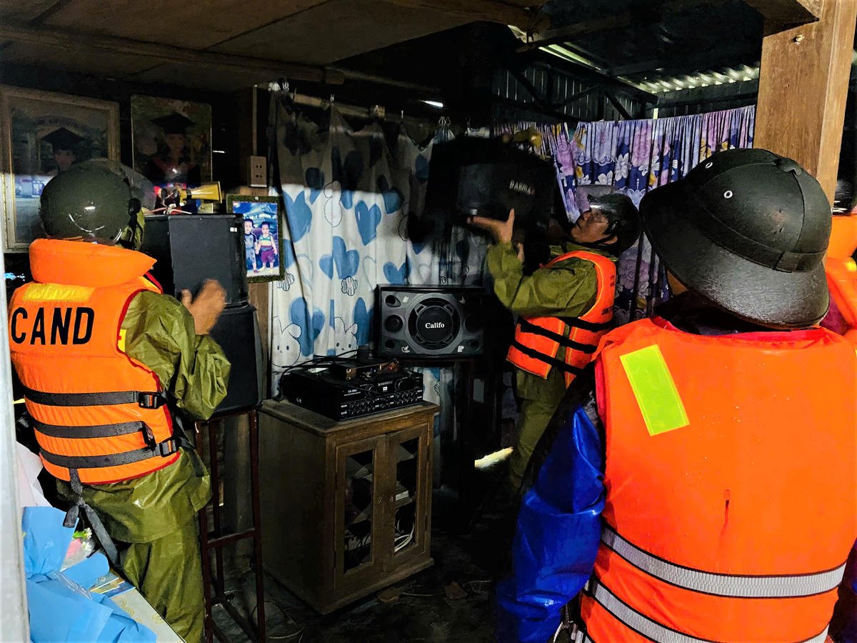 Công an xã Thượng Đức giúp người dân đưa nhiều vật dụng sinh hoạt gia đình lên trên gác. Ảnh: T. Thành.