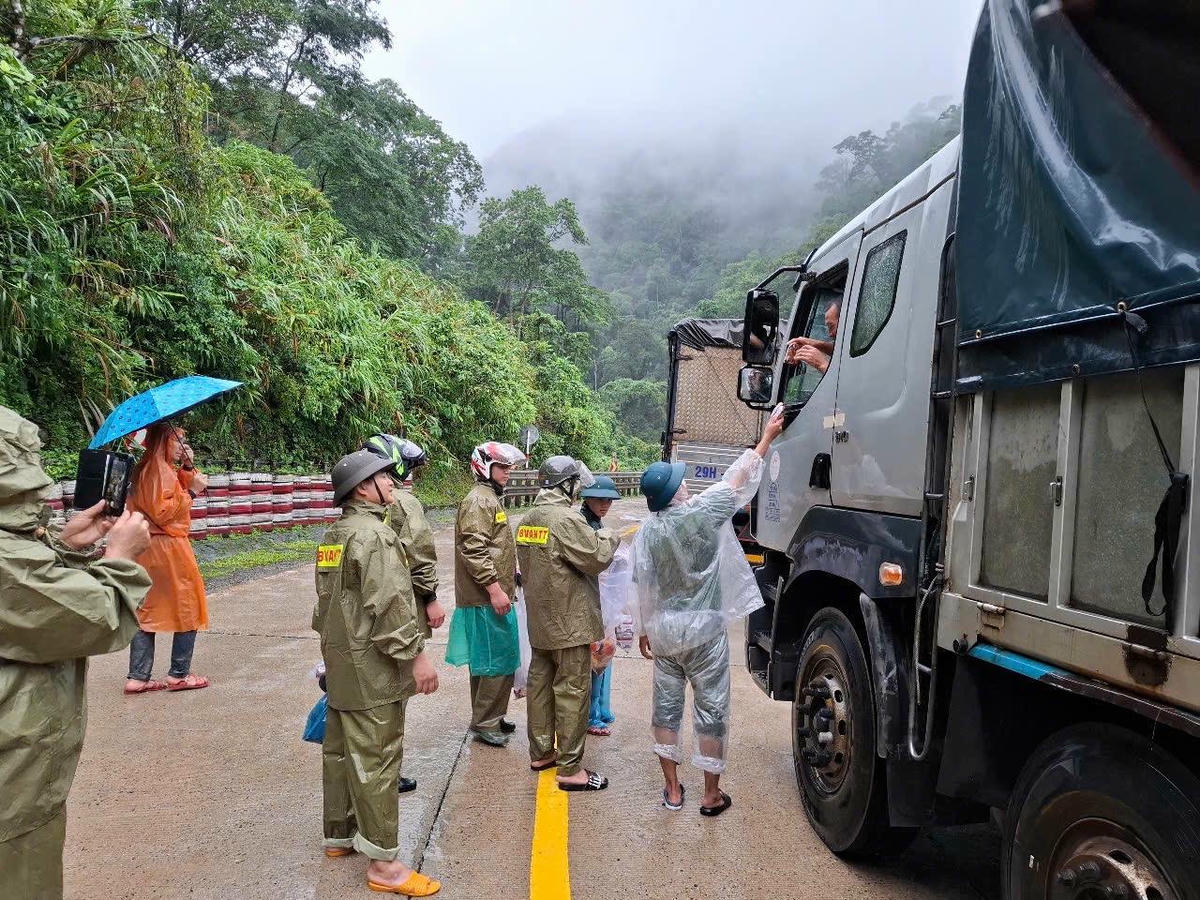 Công an xã xã Phước Năng phối hợp cảnh sát giao thông tặng nước uống, lương thực, mì tôm, bánh mì cho các tài xế và người dân đang mắc kẹt trên đèo. Ảnh: Công an xã.