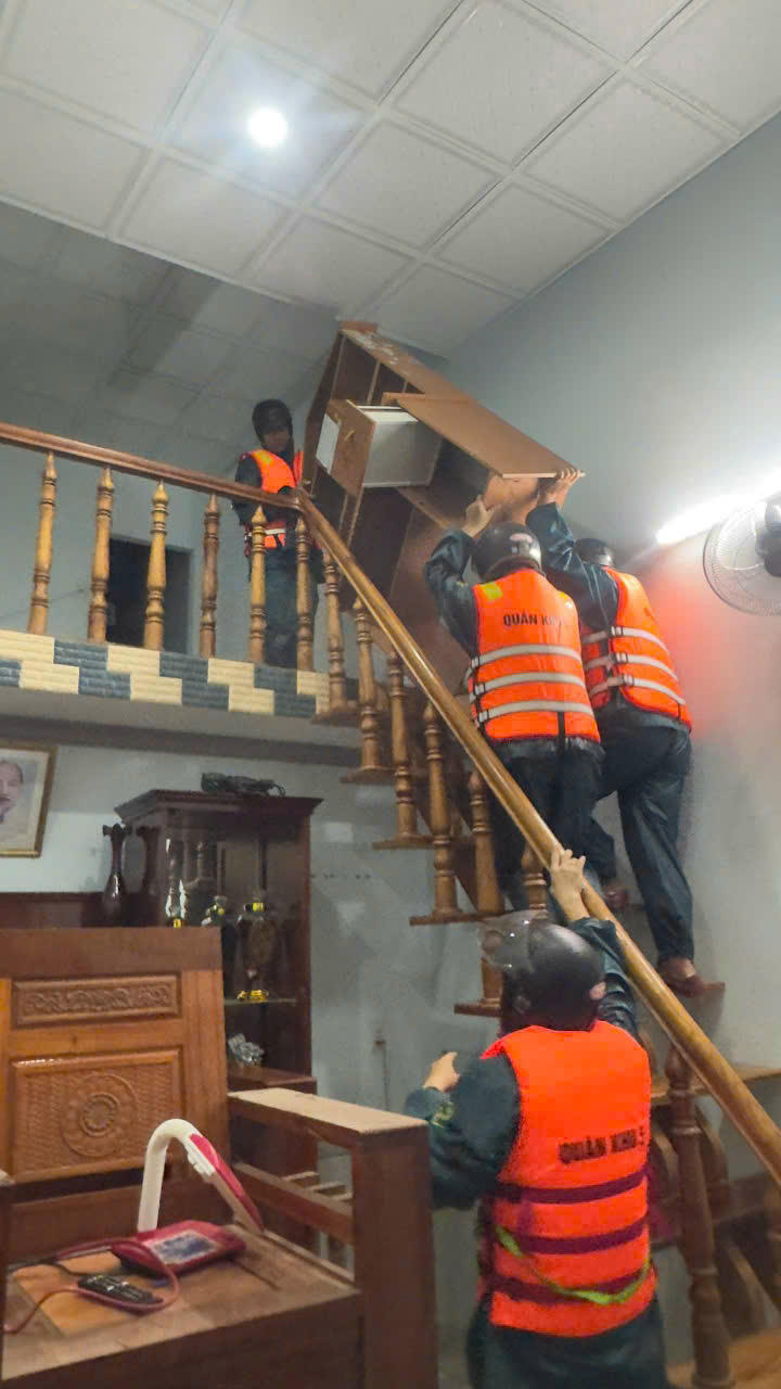 Trong đêm 27/10, lực lượng dân quân giúp dân di dời đồ đạc. Ảnh: Nguyễn Đức Cường