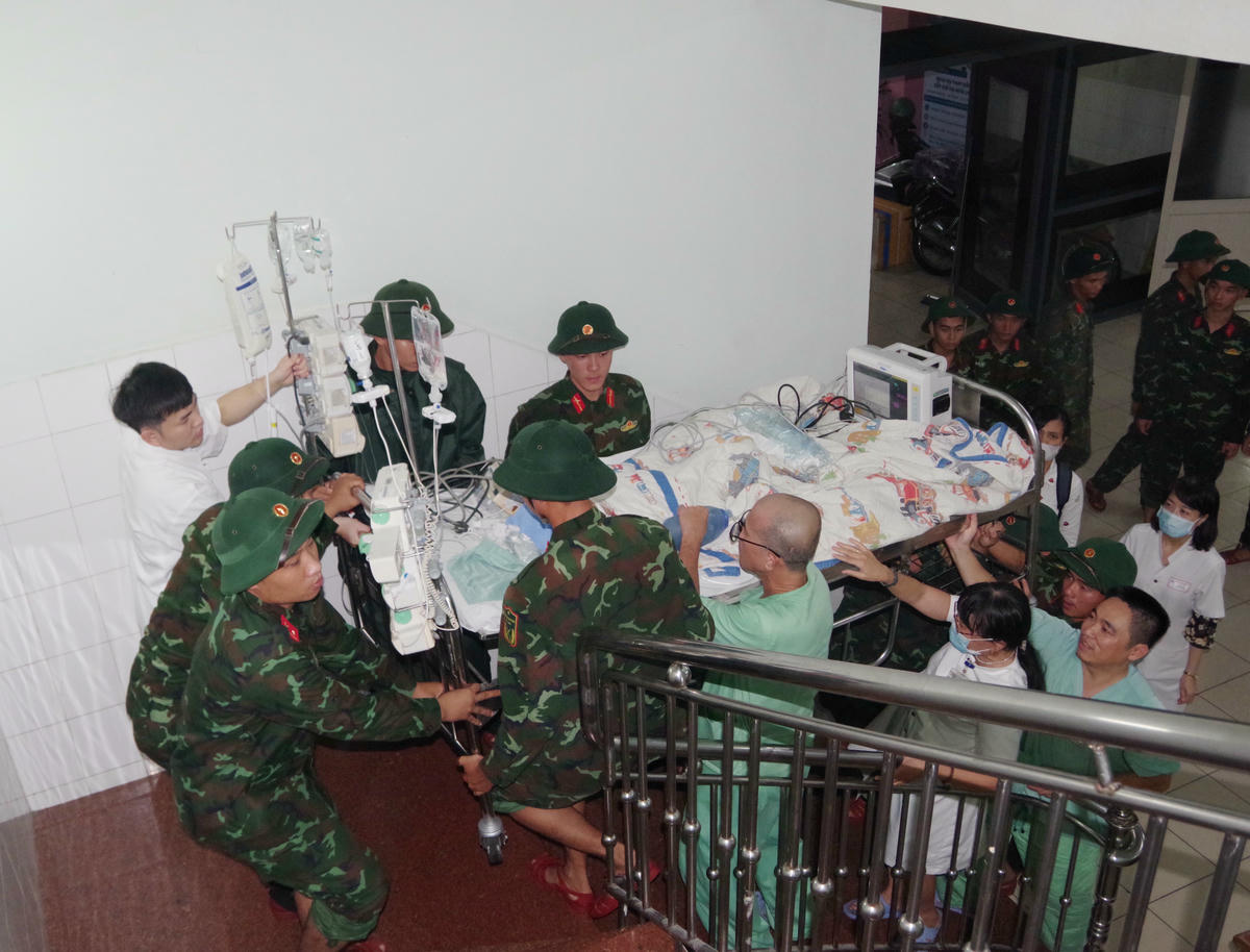 Quân đội cùng các y bác sĩ đưa bệnh nhân đang điều trị tại Bệnh viện Trung ương Huế đến nơi an toàn. Ảnh: Q.Đ.