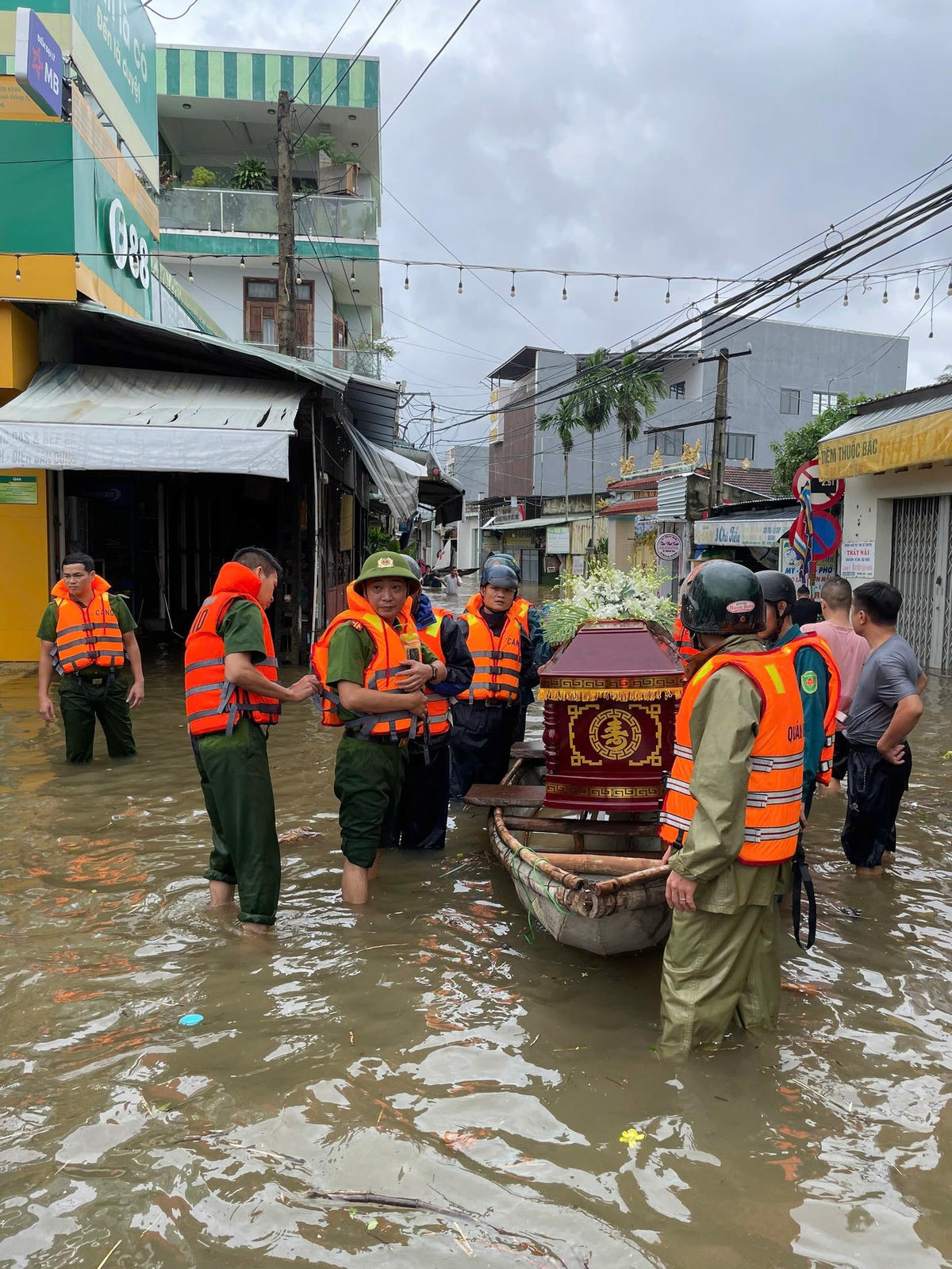 Công an xã Hòa Vang, TP Đà Nẵng phối hợp với lực lượng Cảnh sát đặc nhiệm Bộ Công an và bà con dân cư thôn Tuý Loan Đông 1 đã ngâm mình trong nước lũ đưa linh cữu cụ bà Lâm Thị Đối, thọ 93 tuổi về nơi an nghỉ cuối cùng. Ảnh: Nguyễn Tú..