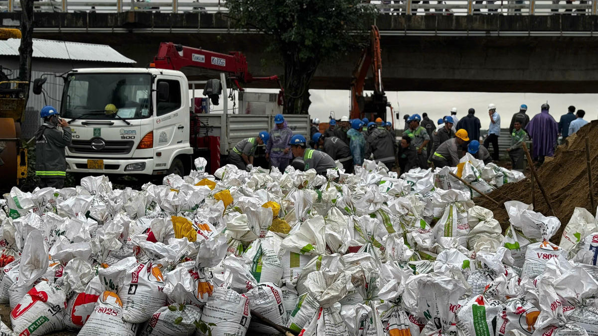 Hàng nghìn bao cát được đưa vào bịt miệng cống.Ảnh: CV.