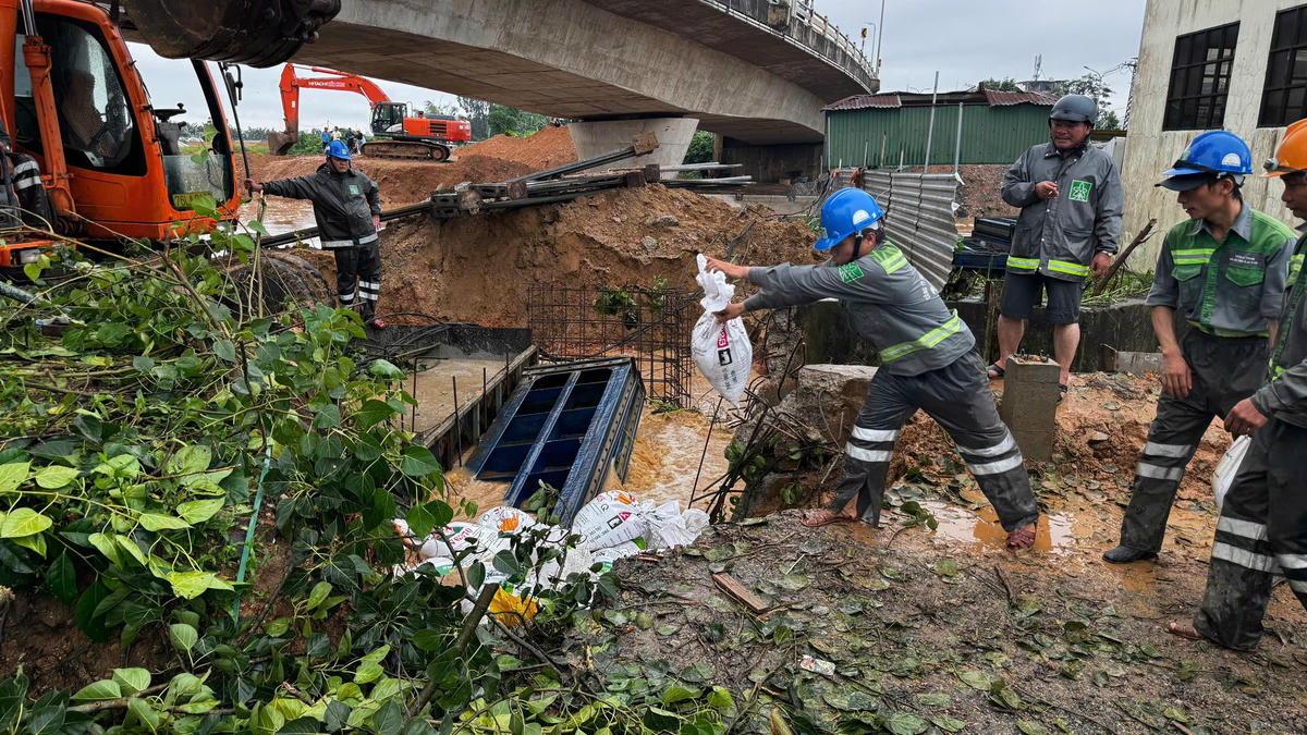 Công nhân đô thi đang đưa bao cát gia cố bịt miếng cống, gần bờ sông Trà Khúc. Ảnh: CV.