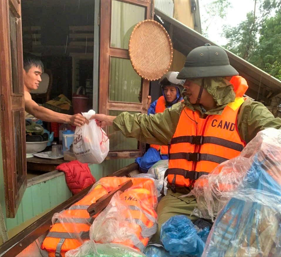 Lực lượng Công an phường Điện Bàn Bắc phát đưa thực phẩm cho người dân vùng lũ. Ảnh: CV.