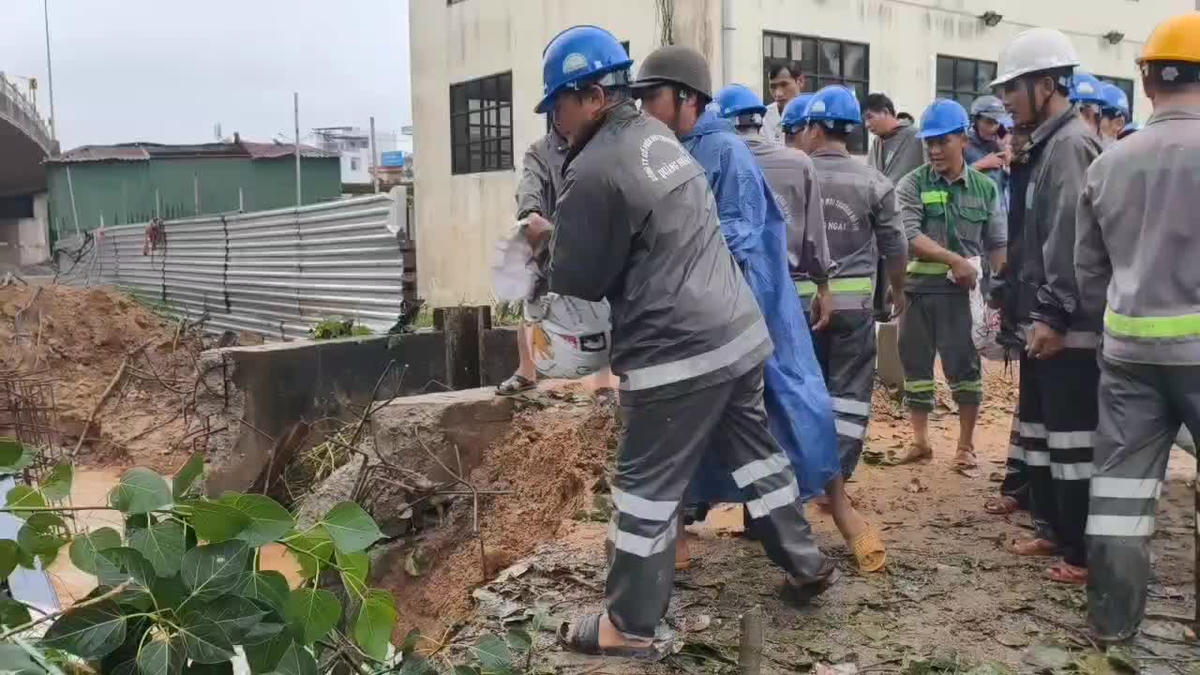 Công nhân đô thị chuyển cát vào bịt miệng cống. Ảnh: CV.