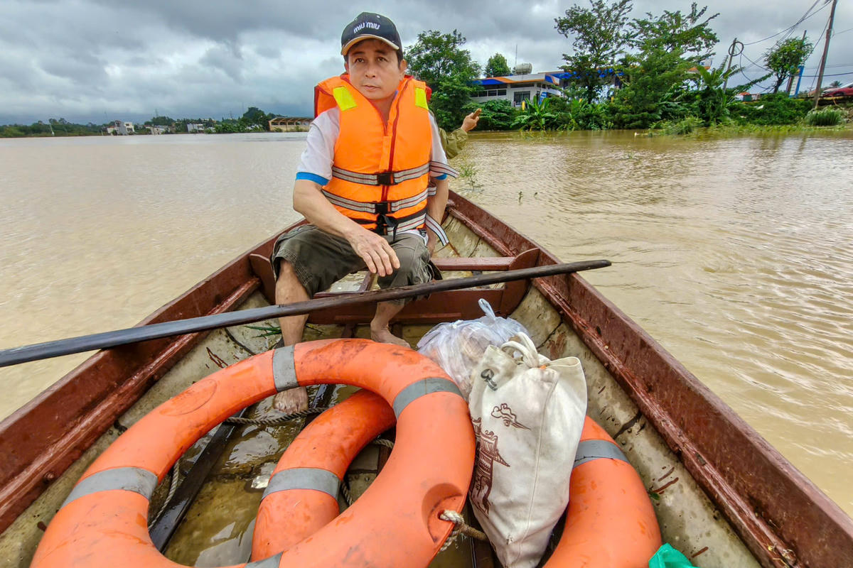 Người dân chèo ghe di chuyển lại khu vực ngập nước sâu. Ảnh: C.Đại.