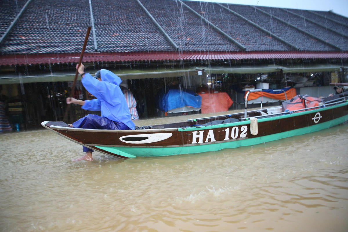Người dân Hội An di chuyển ghe đi lại khu vực ngập sâu. Ảnh: T. Thành.