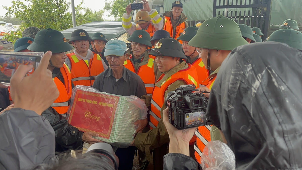 Phó Thủ tướng Trần Hồng Hà tặng quà cho một hộ dân ở vùng ngập lụt phường Điện Bàn Đông. Ảnh: Tấn Thành.