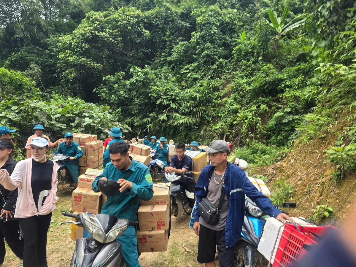 Lực lượng chức năng vận chuyển hàng hoá vào bản Na Ngân cho người dân, vì tuyến đường độc đạo bị chia cắt. Ảnh: HT