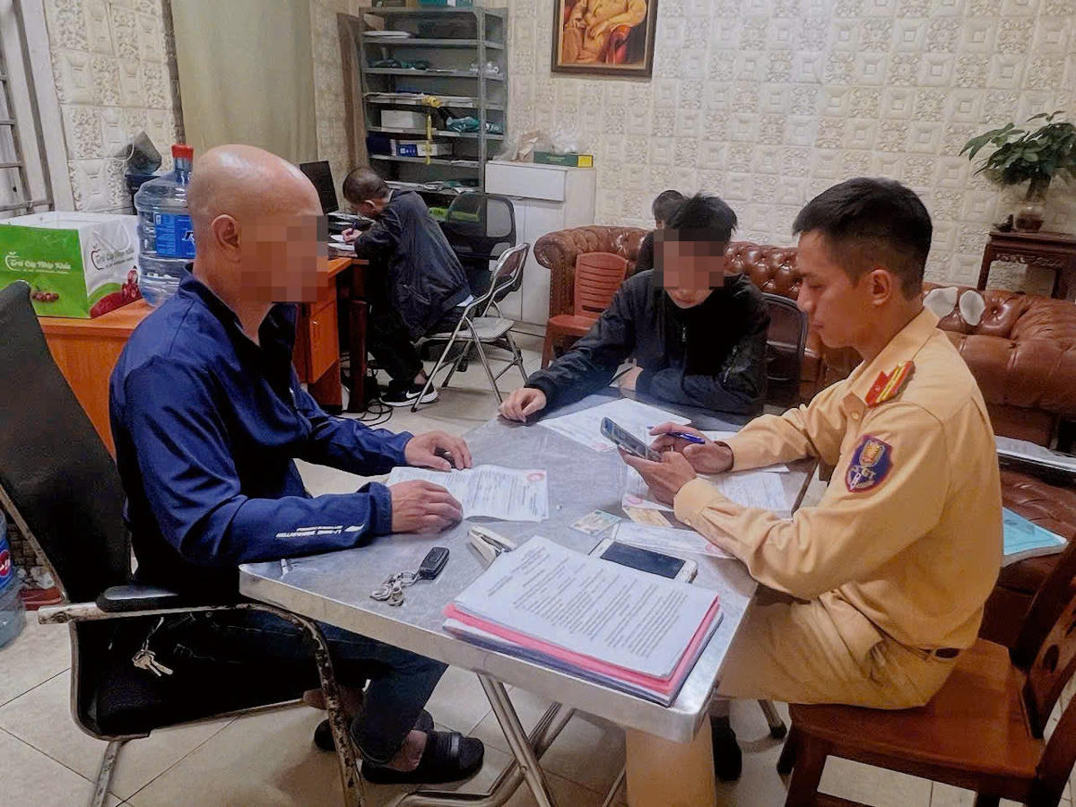 CSGT làm việc với chủ xe, đồng thời là bố của người vi phạm. Ảnh: CACC.