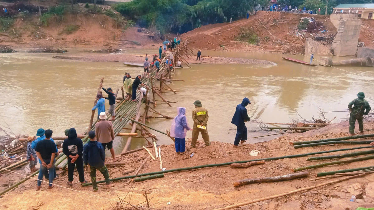 Sau cơn bão số 10, cầu Trung Thắng, xã Yên Hoà bị cuốn trôi, hơn 300 hộ dân với hàng nghìn nhân khẩu rơi vào cảnh bị chia cắt. Chính quyền phải huy động các lực lượng chức năng và người dân làm cầu tre để lưu thông. Ảnh: ĐT