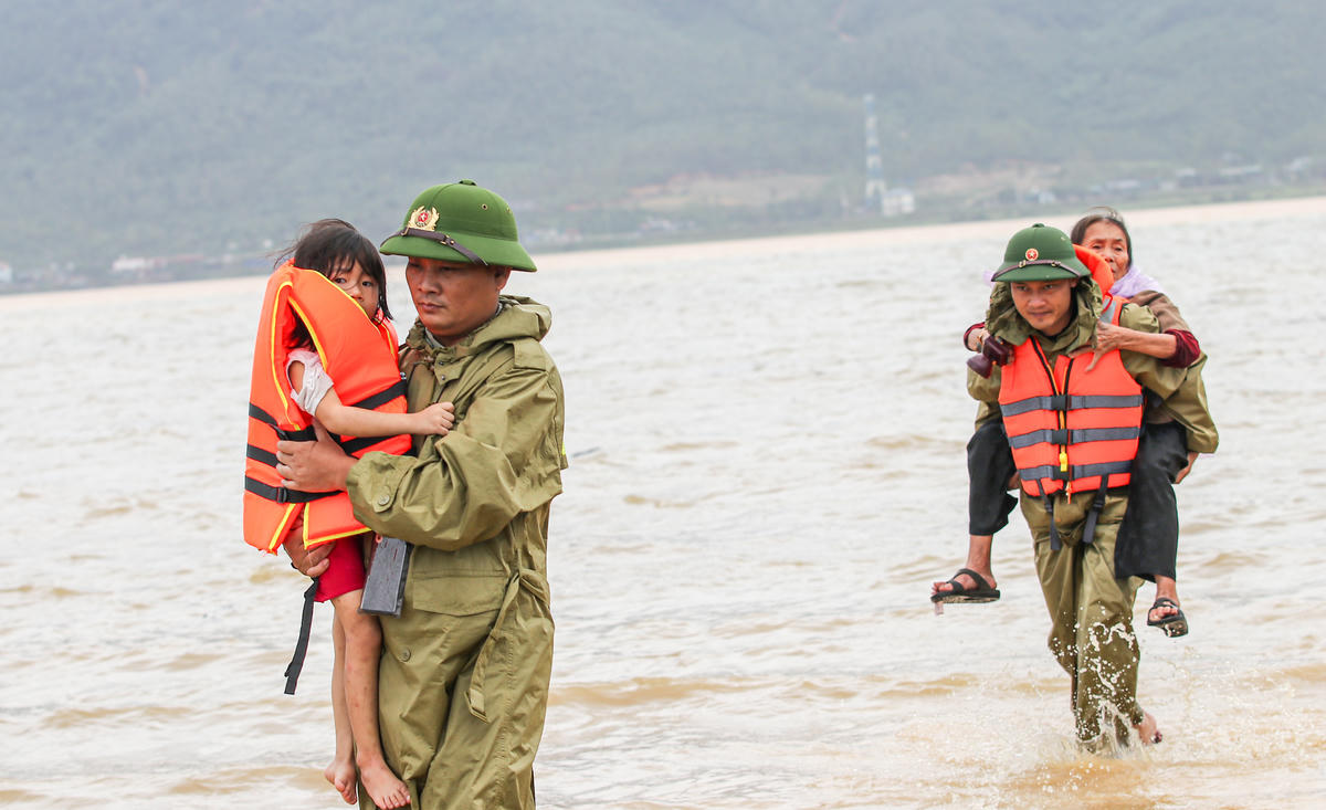 Các tổ công tác đến từng hộ dân bị ngập sâu, đưa người già, trẻ nhỏ và phụ nữ ra khỏi vùng nguy hiểm. Ảnh: Cẩm Kỳ 