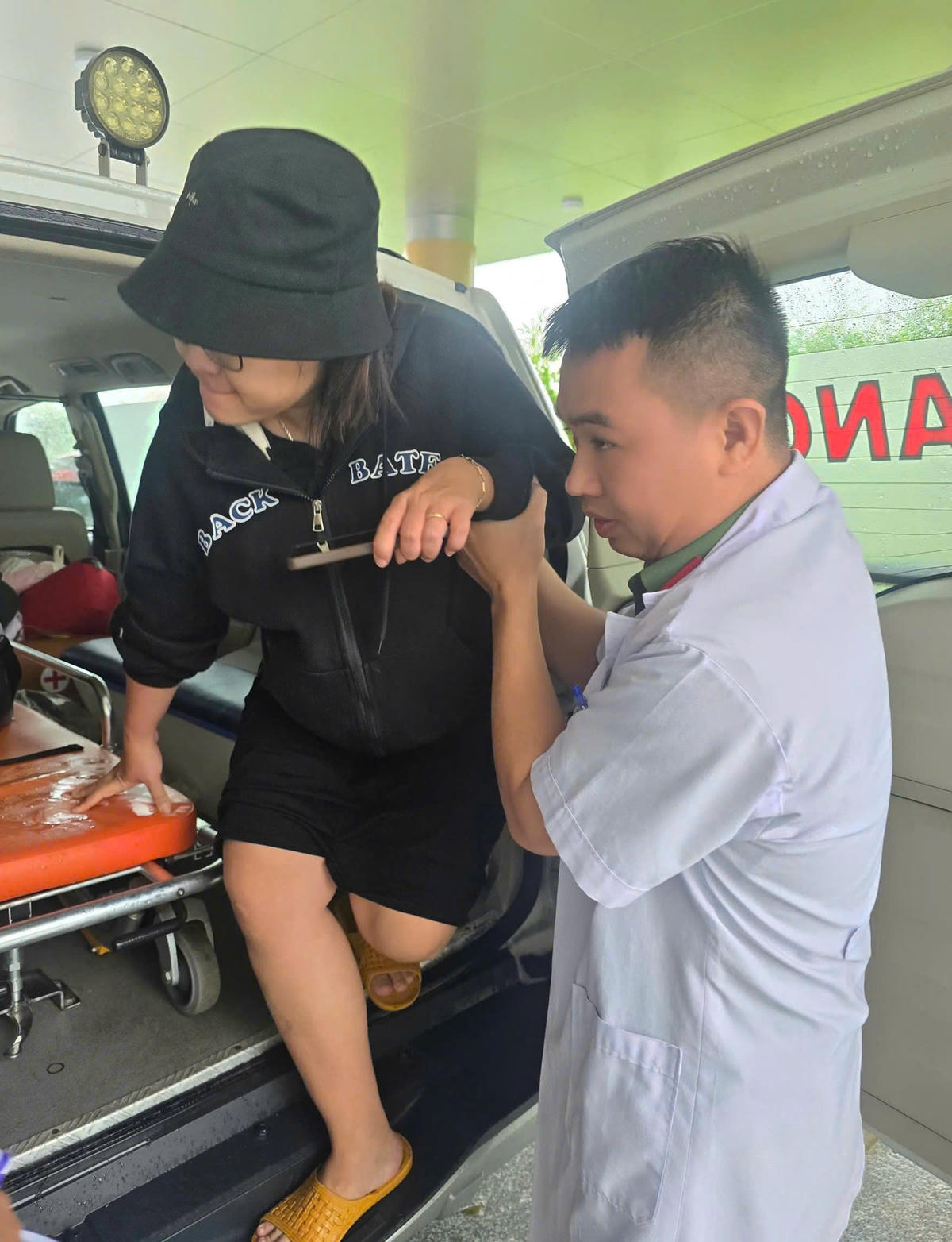 Một thầy thuốc đang giúp người bệnh vùng lũ lên xe đi đến nơi an toàn. Ảnh: Phước Thành.