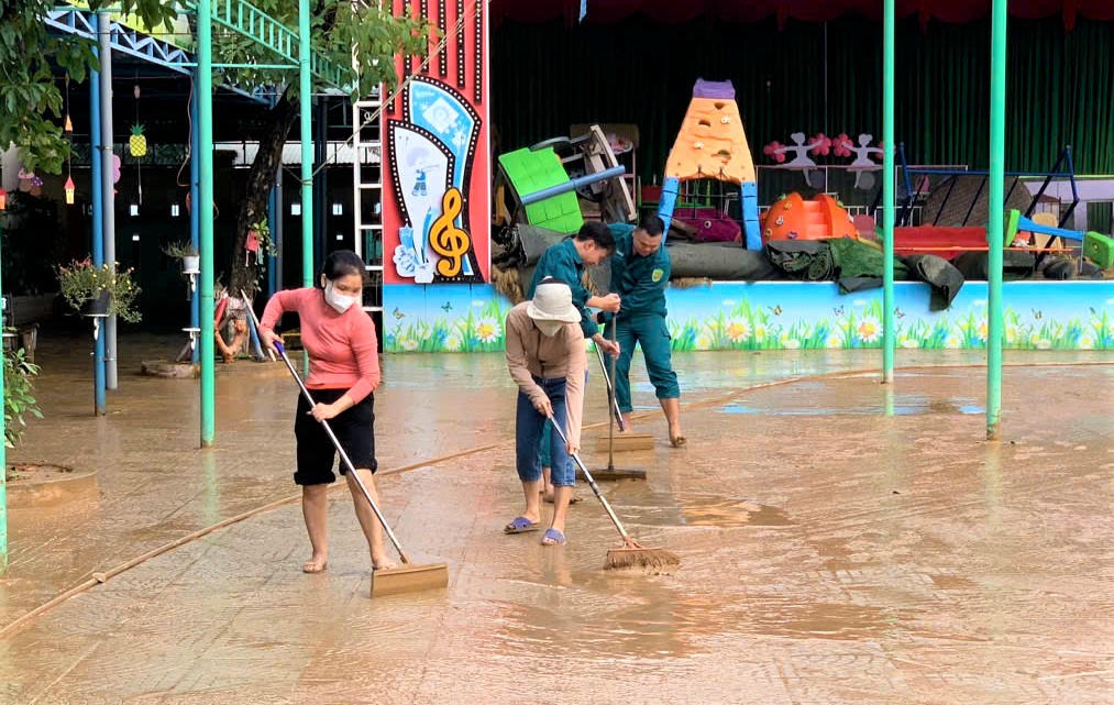 Các cô giáo của Trường mầm non Đại An đang dọn bùn non bám dày trong khuôn viên. Ảnh: CV.