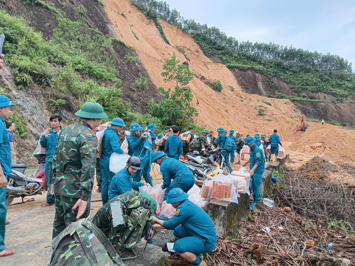 Lực lượng quân đội cùng lãnh đạo xã Trà Tân đưa lương thực vào cho bà con vùng bị cô lập do sạt lở đất đá. Ảnh: CV.