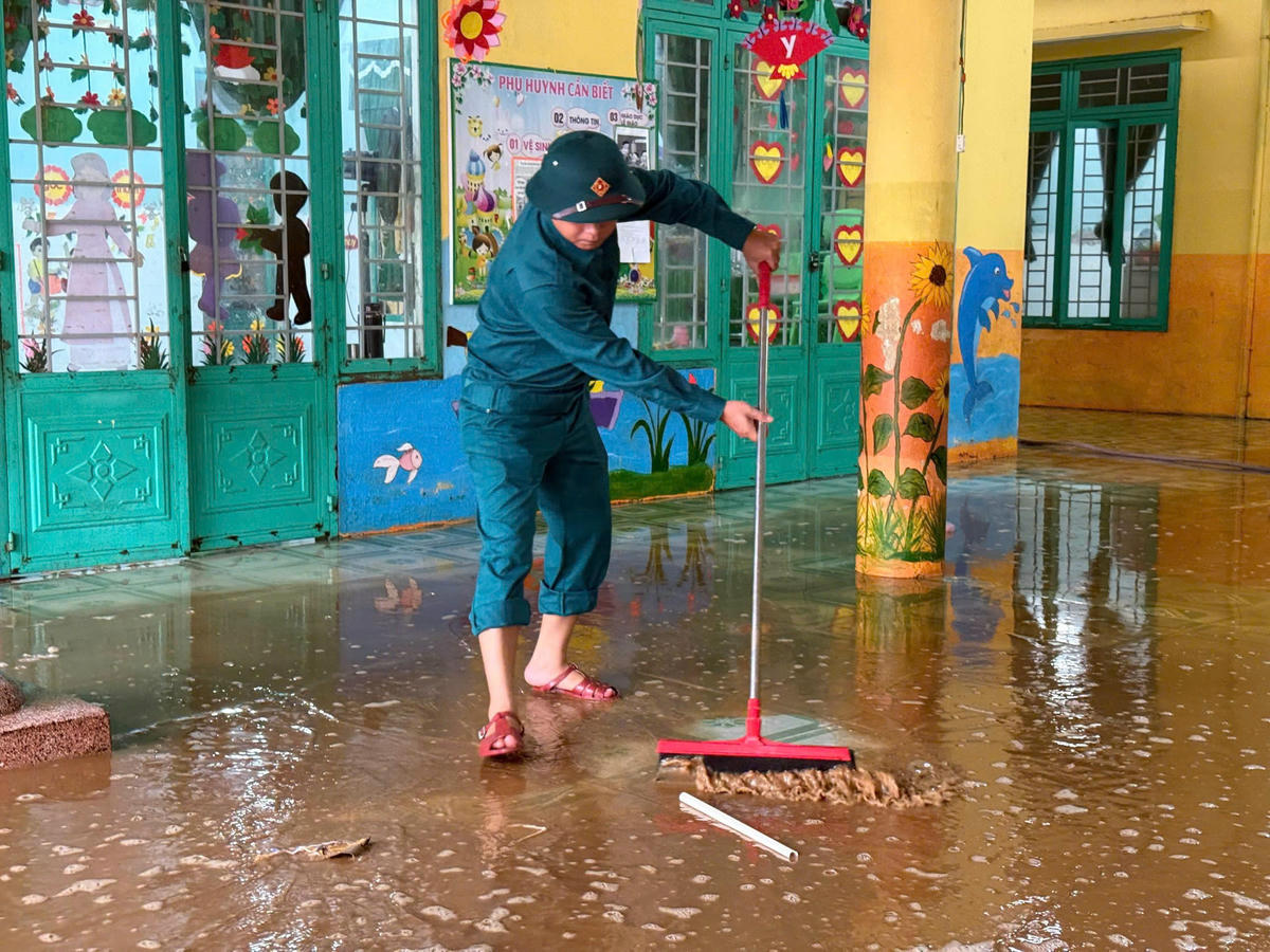 Dân quân giúp nhà Trường Mầm non ở xã Phước Giang, tỉnh Quảng Ngãi, don dẹp bùn sau lũ. Ảnh: Nguyễn Tín.