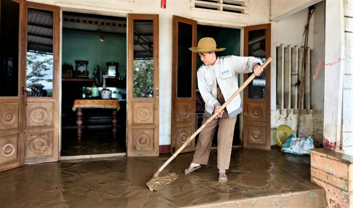 Nhiều người dân xã Bình Minh đang dọn bùn đất sau khi lũ rút xuống. Ảnh: Chí Đại.