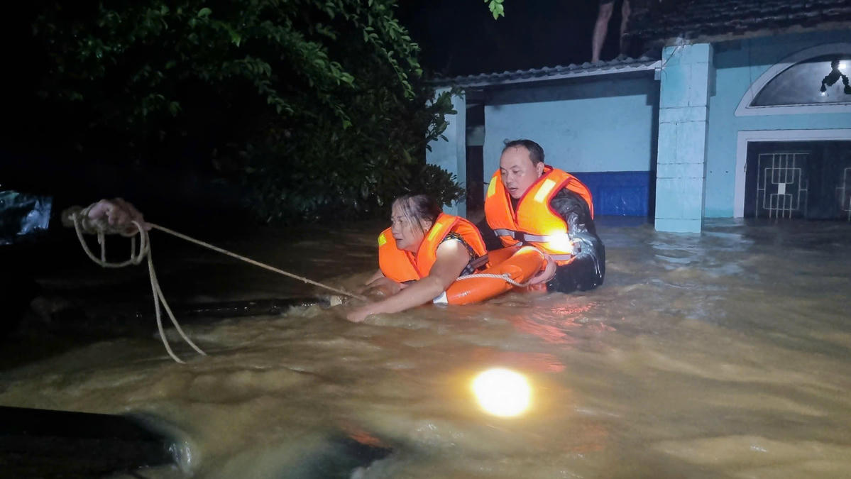 Lực lượng chức năng xã Đại Lộc, TP Đà Nẵng đang giải cứu bà Trần Thị Bốn trong ngôi nhà ngập nước sâu. Ảnh: CV.