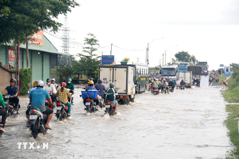 Quốc lộ 28 đoạn qua địa bàn phường Hàm Thắng (Lâm Đồng) bị ngập sâu, các phương tiện di chuyển khó khăn. (Ảnh: Nguyễn Thanh/TTXVN).