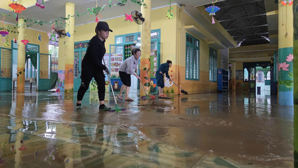 Thầy, cô giáo trưởng mầm non xã Phước Giang, tỉnh Quảng Ngãi dọn bùn đất. Ảnh: Chí Đại.