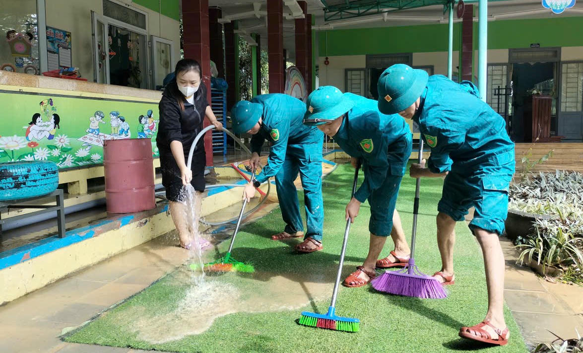 Lực lượng dân quân TP Đà Nẵng dọn dẹp bùn đất giúp nhà trường đón học sinh đi học trở lại. Ảnh: CV.