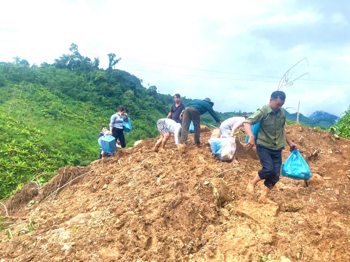Cô giáo Trường mầm non Hoa Mai cùng ban công tác Mặt trận thôn Tắk Pỏ vượt điểm sạt lở đưa cơm cho bà con bị cô lập. Ảnh: CV.