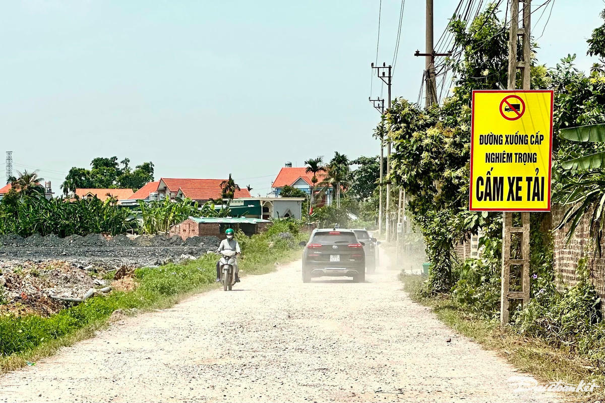 Đầu đường Vũ Tướng (đoạn qua khu phố Động Linh) gắn biển cảnh báo "Đường xuống cấp nghiêm trọng - Cấm xe tải". Ô tô đi qua con đường này cuốn theo bụi bay mù mịt. Ảnh: Ngọc Anh.