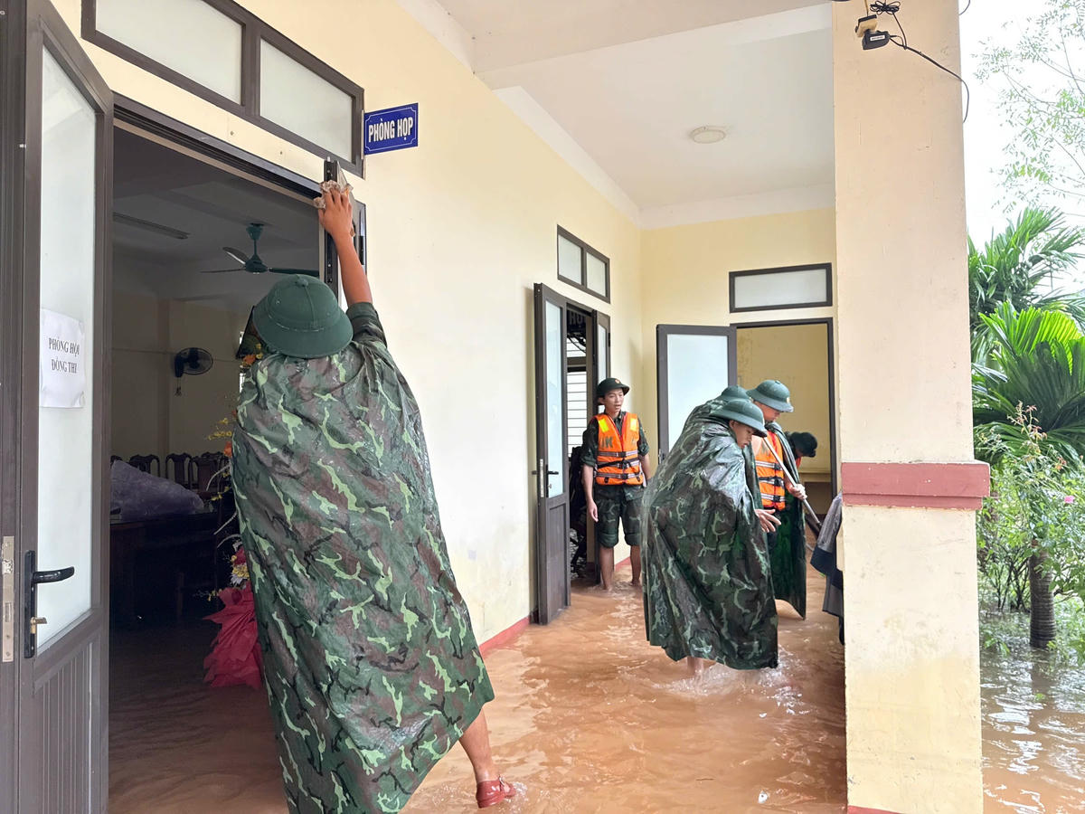 Lực lượng quân sự hỗ trợ nhân dân tâm lũ Cẩm Duệ khắc phục hậu quả mưa lũ. Ảnh: ĐS.