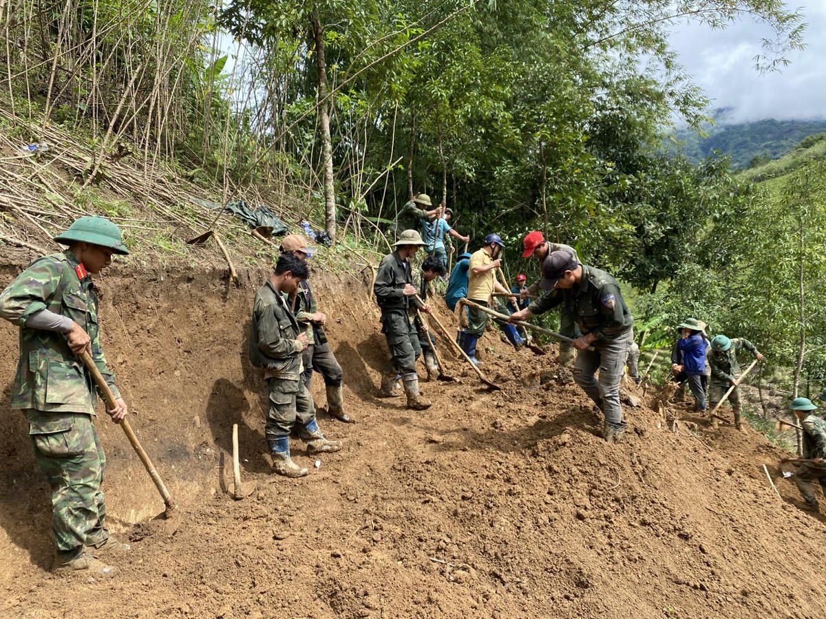Cán bộ, chiến sĩ cùng người dân xã Ngọc Linh đang khắc phục các điểm sạt lở đất đá trên địa bàn. Ảnh: CV.