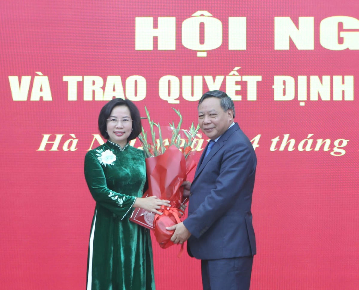 Phó Bí thư Thường trực Thành ủy Nguyễn Văn Phong trao Quyết định và tặng hoa bà Bùi Huyền Mai.