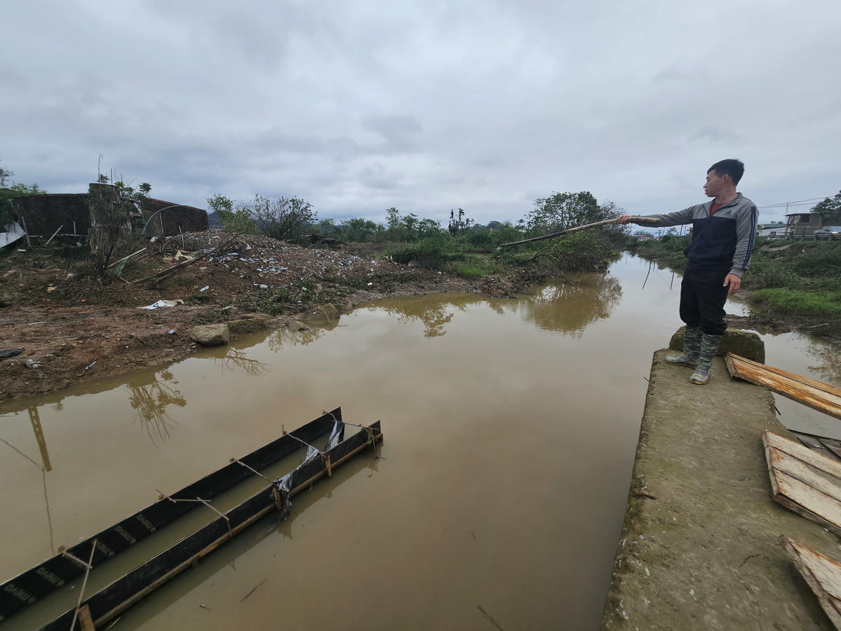 Anh Nguyễn Doãn Nghĩa chỉ cho phóng viên các khối bê tông vỡ ra từ mố cầu đang thi công. Ảnh: Quốc Thanh.