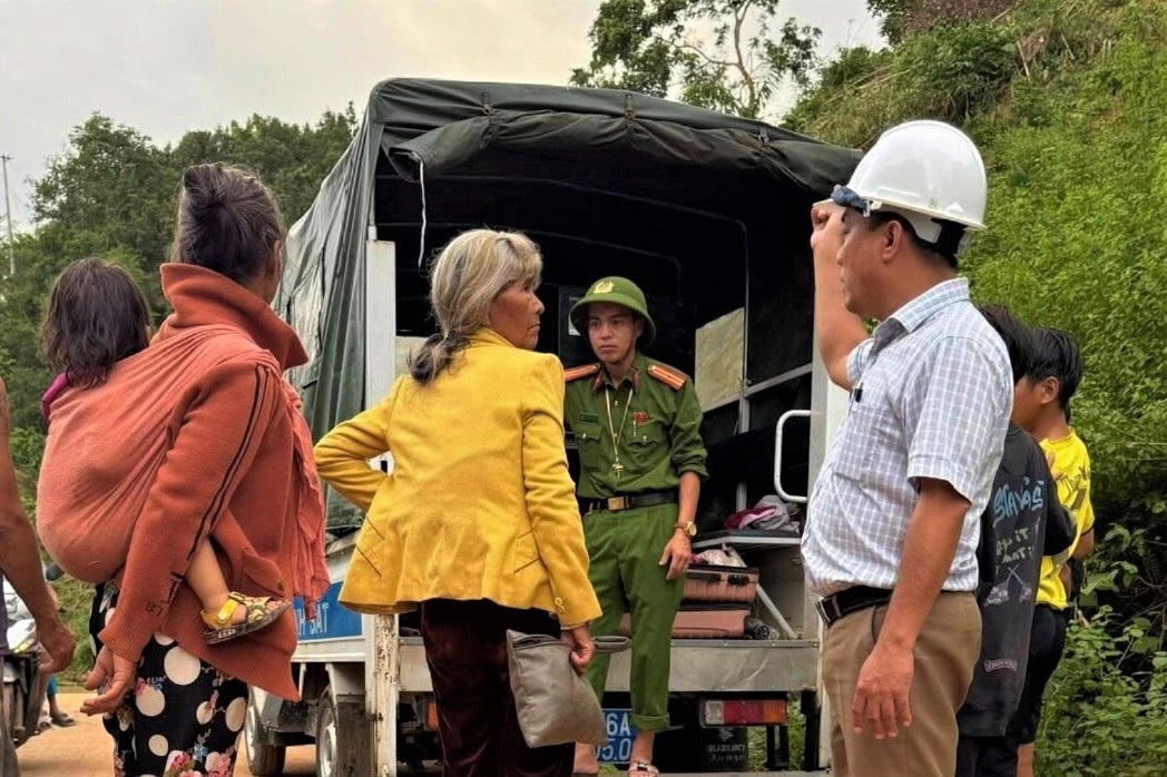 Lực lượng dân quân và công an xã Tây Trà Bồng hỗ trợ người dân di chuyển đồ đạc ra khỏi khu vực có nguy cơ sạt lở. Ảnh: ĐPCC