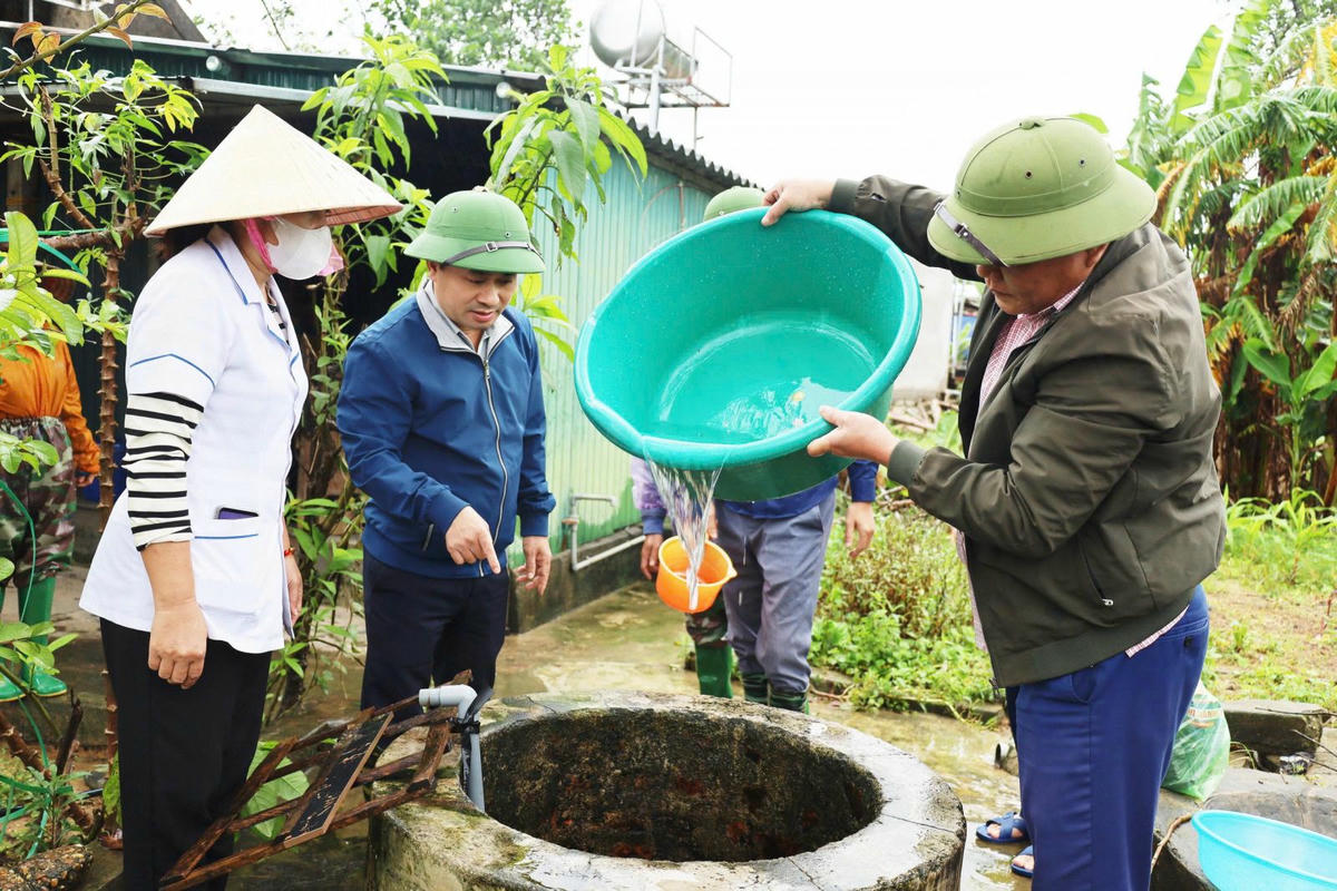 Ông Nguyễn Chí Thanh, Giám đốc CDC Hà Tĩnh cùng đoàn hỗ trợ người dân xứ lý nước sinh hoạt sau mưa lũ. Ảnh: NT.