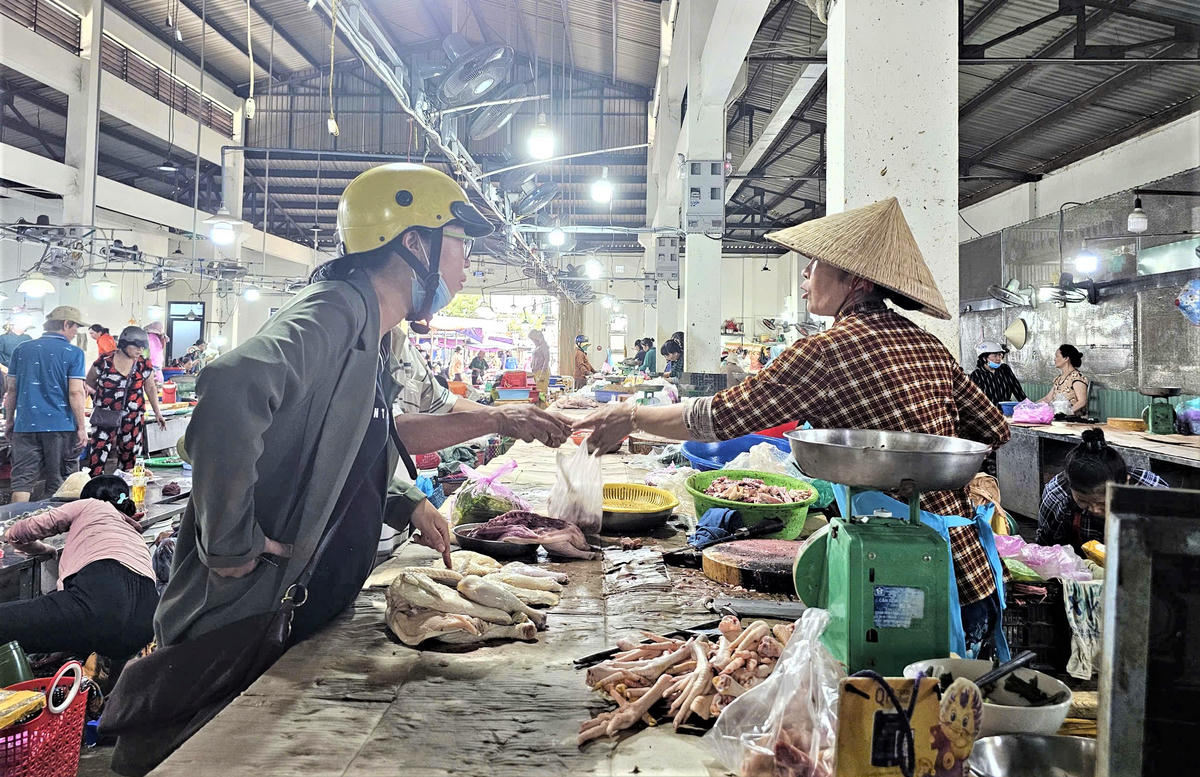 Bà Nguyễn Thị Huế đang bán gà cho người dân. Ảnh: Tấn Thành.