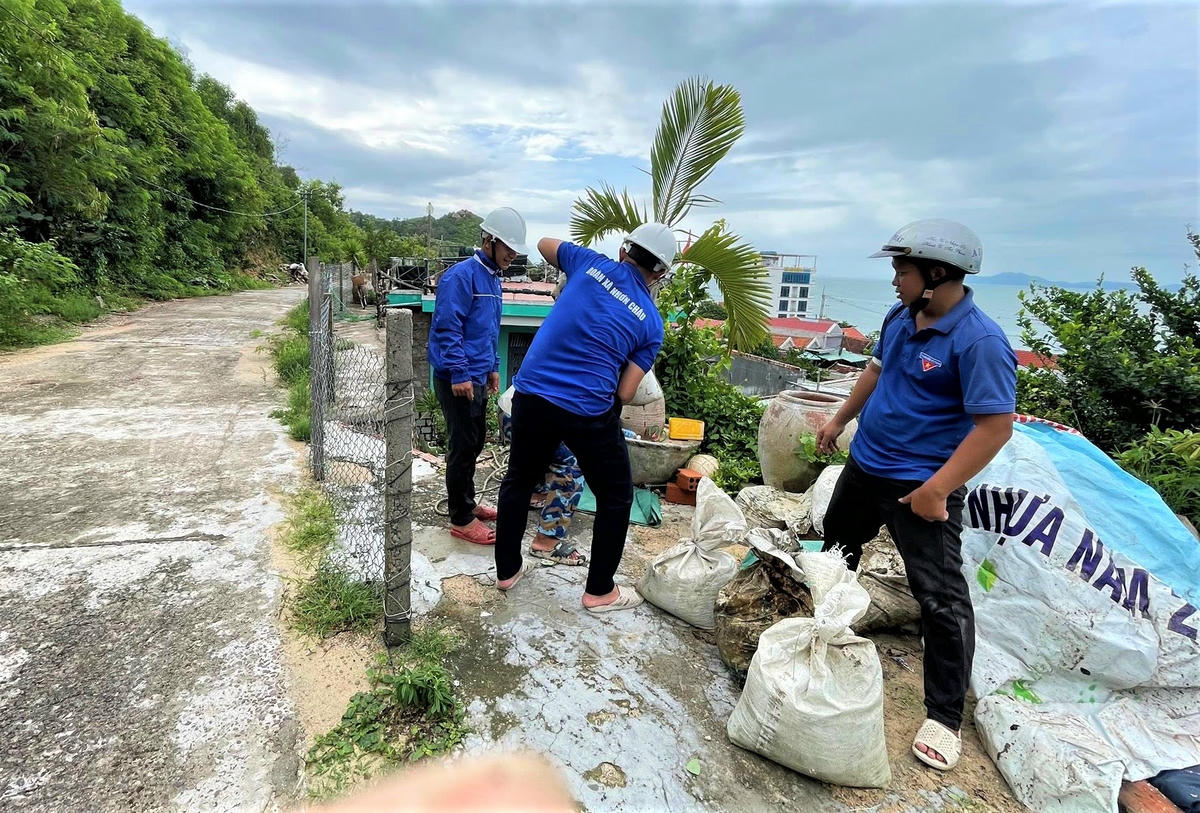 Lực lượng thanh niên xã Nhơn Châu khẩn trương vận chuyển bao cát giúp người dân chằng chống, gia cố nhà cửa phòng bão số 13. Ảnh: CV.